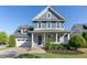 Charming two-story home featuring blue siding, a covered porch, and an attached two-car garage at 208 Vervain Way, Holly Springs, NC 27540