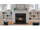 Fireplace with black tile surround and custom built-in shelving creates a cozy focal point at 208 Vervain Way, Holly Springs, NC 27540