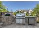 A beautifully designed outdoor kitchen with a pizza oven, grill, and stainless steel refrigerator perfect for entertaining at 208 Vervain Way, Holly Springs, NC 27540
