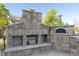 Outdoor kitchen area complete with a pizza oven and fireplace at 208 Vervain Way, Holly Springs, NC 27540