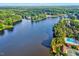Scenic aerial shot of a lake, showcasing houses, pool, and tennis courts along the shoreline at 212 Ronaldsby Dr, Cary, NC 27511