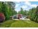 Lush backyard featuring mature trees and a well-maintained lawn, creating a serene and private outdoor space at 212 Ronaldsby Dr, Cary, NC 27511