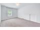 Bright bedroom features ample natural light, neutral carpet, and closet space, creating a versatile and inviting space at 212 Ronaldsby Dr, Cary, NC 27511