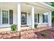 Close-up of the front porch with brick steps, columns, and potted flowers at 212 Ronaldsby Dr, Cary, NC 27511