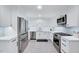 Updated kitchen featuring modern stainless steel appliances, white cabinets, and gray tile flooring at 212 Ronaldsby Dr, Cary, NC 27511