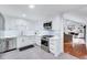 This modern kitchen showcases white cabinetry, stainless steel appliances, and seamless flow into living area at 212 Ronaldsby Dr, Cary, NC 27511