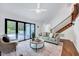 Bright living room features hardwood floors, staircase, and doors to the outside at 212 Ronaldsby Dr, Cary, NC 27511