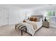 Serene primary bedroom offers neutral tones, plush carpet, and ample natural light, creating a relaxing retreat at 212 Ronaldsby Dr, Cary, NC 27511