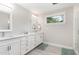 Bright bathroom featuring double vanity, sleek white cabinets, and contemporary tile floors at 219 Northwood Cir, Durham, NC 27701