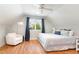 Cozy bedroom features a comfy armchair, light hardwood flooring, and a ceiling fan at 219 Northwood Cir, Durham, NC 27701