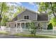 Charming two-story home with gray siding, white trim, and a welcoming front porch and a nice white picket fence at 219 Northwood Cir, Durham, NC 27701