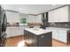 Modern kitchen featuring white cabinets, stainless steel appliances, gray tile backsplash and a gray island at 219 Northwood Cir, Durham, NC 27701