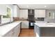 Bright kitchen with white cabinets, stainless steel appliances, ample counter space and hardwood floors at 219 Northwood Cir, Durham, NC 27701