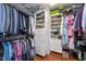 Organized walk-in closet featuring custom shelving, hanging rods and shoe racks, with a variety of clothing and shoe selections at 2202 Environ Way # Bldg 2000, Chapel Hill, NC 27517