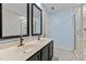 Stylish bathroom featuring double sinks, dark cabinetry, and a glass-enclosed shower at 2210 Raven Rd # 105, Raleigh, NC 27614