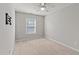 Neutral bedroom with carpeted floors, ceiling fan, and bright window with natural light at 2210 Raven Rd # 105, Raleigh, NC 27614