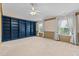 Large bedroom with a ceiling fan, windows, and built-in shelving at 2210 Raven Rd # 105, Raleigh, NC 27614