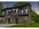 Modern townhome showcasing a striking gray facade, brick accents, and a well-manicured lawn at 2325 Sheffield Rd # 102, Raleigh, NC 27610