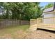 Backyard view showcasing a wooden deck with stairs leading to a grass yard and a wooden privacy fence at 2402 Cynthia Dr, Durham, NC 27704