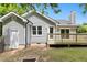 The backyard features a wooden deck, a small yard, privacy fence, a firepit, and access to the side door of the house at 2402 Cynthia Dr, Durham, NC 27704