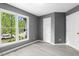 Corner bedroom featuring large windows, hardwood flooring, gray walls, and white doors at 2402 Cynthia Dr, Durham, NC 27704