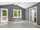 Bedroom showcasing hardwood flooring, gray walls, a ceiling fan, and an exterior door at 2402 Cynthia Dr, Durham, NC 27704