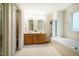 Bright bathroom features a double vanity, soaking tub, and unique glass block window for natural light at 244 Sweet Bay Pl, Carrboro, NC 27510