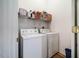 Laundry room with a front loading washer and dryer, metal shelving, and laminate flooring at 244 Sweet Bay Pl, Carrboro, NC 27510
