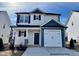 Charming two-story home with blue and light gray accents, featuring a one-car garage and well-maintained landscaping at 251 Bluejay St, Clayton, NC 27520