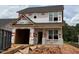 Two-story home under construction, displaying the exterior elevation, windows, and the initial stages of the building process at 256 Bluejay St, Clayton, NC 27520