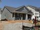 New single-story home with gray siding and a covered front porch in a developing neighborhood at 257 Bluejay St, Clayton, NC 27520
