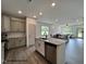 Open-concept kitchen flows into the living area, featuring stainless steel appliances, an island, and hardwood floors at 257 Bluejay St, Clayton, NC 27520