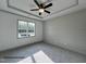 Calming bedroom features a large window, modern ceiling fan, and neutral color scheme with carpeted floors at 257 Bluejay St, Clayton, NC 27520