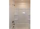 Clean, white bathroom shower and tub with built-in shelving and chrome fixtures at 261 White Oak Ridge Dr, Garner, NC 27529