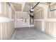 Unfinished garage featuring concrete floor, overhead door hardware, and a hot water heater at 261 White Oak Ridge Dr, Garner, NC 27529