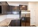 Close-up view of the kitchen with stainless steel refrigerator and dark wood cabinets at 261 White Oak Ridge Dr, Garner, NC 27529