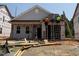 New construction home featuring gray siding, black roof, and front porch in a residential neighborhood at 262 Bluejay St, Clayton, NC 27520