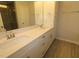 Bathroom featuring double sinks with granite countertops, a large mirror, and neutral tile flooring at 3020 Freewinds Way # 47, Cary, NC 27519