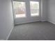 A neutral-toned bedroom boasts soft carpeting, modern paint, and two windows for ample natural light at 3020 Freewinds Way # 47, Cary, NC 27519