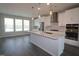 Modern kitchen featuring a large island, stainless steel appliances, and sleek white cabinetry at 3020 Freewinds Way # 47, Cary, NC 27519
