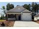 Charming single-story home featuring a blue door, garage and a well-lit porch at 31 Goldenrod Loop, Clayton, NC 27520