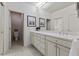 Bright bathroom features a double sink vanity, framed art, and tiled floors at 312 Troon Village Ln, Cary, NC 27511