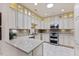 Bright kitchen features white cabinetry, granite countertops, stainless steel appliances, and a skylight at 312 Troon Village Ln, Cary, NC 27511