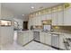 Bright kitchen features white cabinetry, granite countertops, stainless steel appliances, and access to dining area at 312 Troon Village Ln, Cary, NC 27511