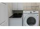 Functional laundry room with a white front-load washer and dryer and built in shelves at 312 Troon Village Ln, Cary, NC 27511