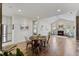 Bright living area boasts hardwood floors, fireplace, vaulted ceilings, and dining area with round table and seating for four at 312 Troon Village Ln, Cary, NC 27511