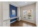 Well-lit office space with custom built-in desk, storage cabinets, drawers, and large window overlooking the outdoors at 312 Troon Village Ln, Cary, NC 27511