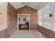 Cozy sunroom featuring exposed brick walls, tile floors, and large windows for ample natural light at 312 Troon Village Ln, Cary, NC 27511