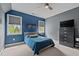 Bright bedroom with a blue accent wall, a large window, and gray furnishings, offering a stylish and calming retreat at 321 Nortwick Rd, Rolesville, NC 27571