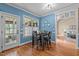 A dining area with blue walls, a black table and chairs, and hardwood floors. The table has decor on it at 321 Nortwick Rd, Rolesville, NC 27571